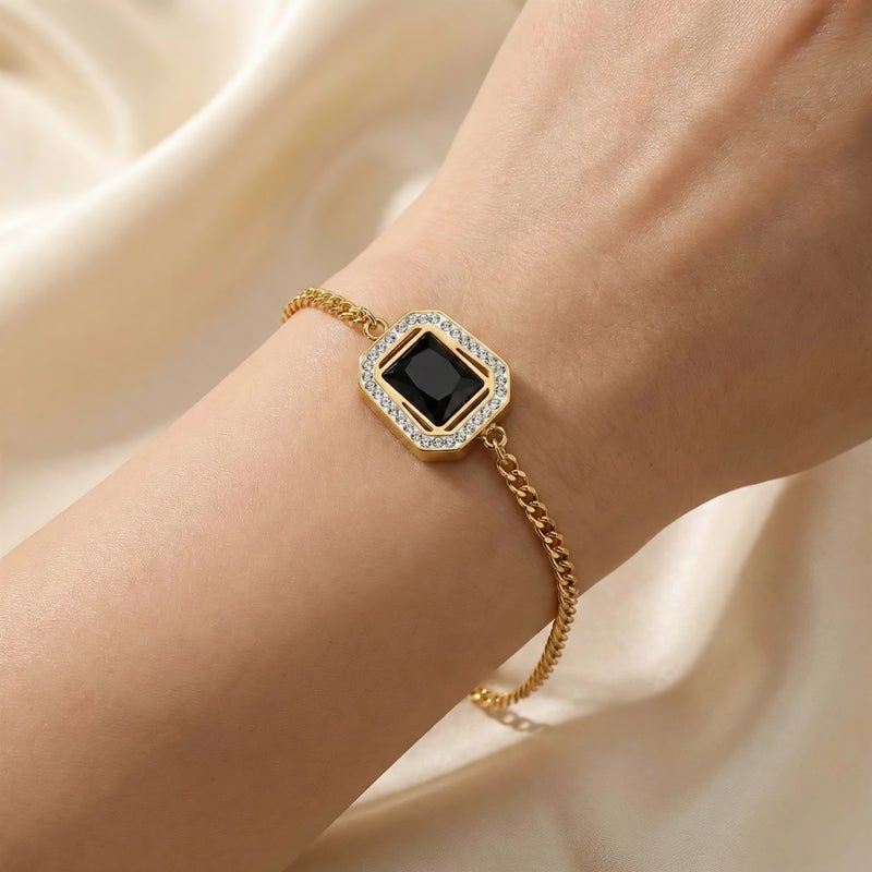 انسيال ذهبي مصنوع من الستانلس ستيل المقاوم للصدأ، بحجر أسود ملكي محاط بإطار مرصع بالزركون اللامع. تصميم رقيق فاخر، مع قفل قابل للتعديل ليناسبكِ. - Image 2